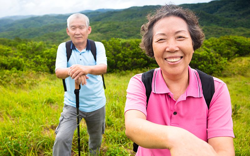 happy senior couple hiking on a mountain