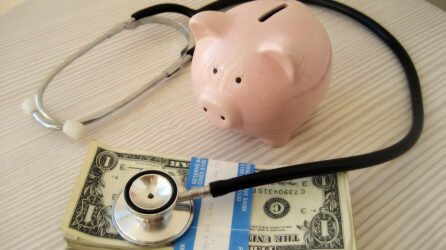 Piggy bank, stethoscope and dollar bills