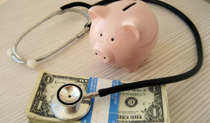 Piggy bank, stethoscope and dollar bills