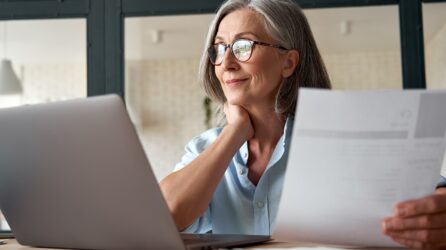 Smiling middle aged woman using laptop computer