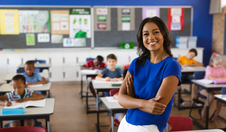 A smiling female teacher standing in front of her class
