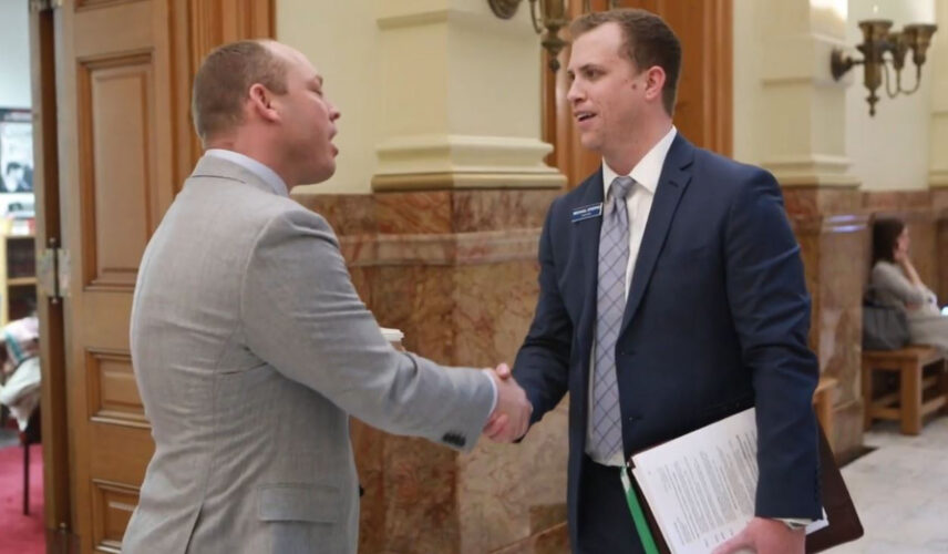 Two men shaking hands inside the Colorado State Capitol building