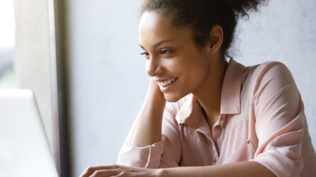 Woman smiling and looking at laptop screen