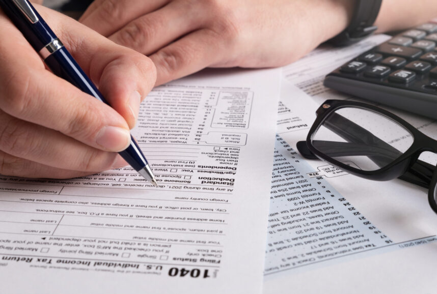 A closeup view of a person filling out a 1040 tax form