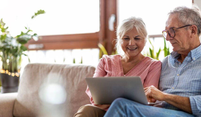 Mature couple using a laptop while relaxing at home